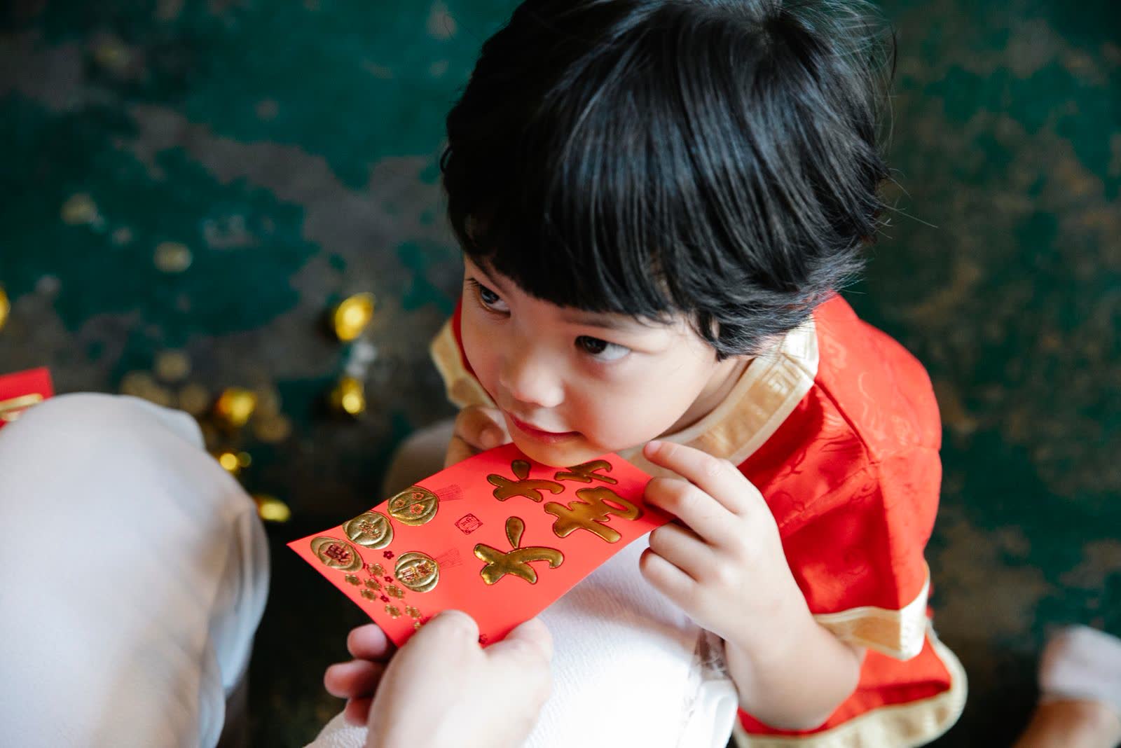 A small child holding a red envelope